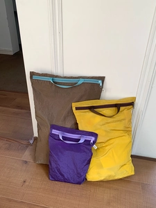Three sizes of ultra-light travel packing cubes in brown, yellow and purple colors