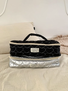 Close-up of black and silver heart-quilted travel organizer bags for hair styling tools