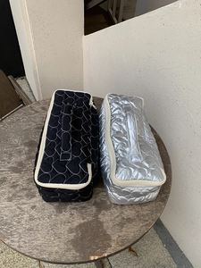 Detail view of quilted heart pattern storage bags in black and silver on a wooden table