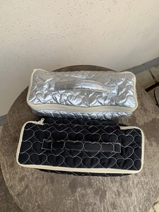 Detail of silver and black quilted storage bags with heart patterns and handles