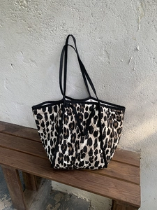 Detail of the leopard print quilted tote bag with black strap and fabric texture