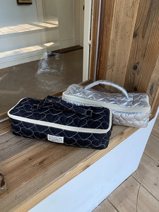 Detail of heart-quilted hair dryer organizer bag with metallic finish and top handle