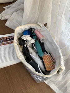 Macro view of silver quilted storage bag showing spacious interior with hair styling tools