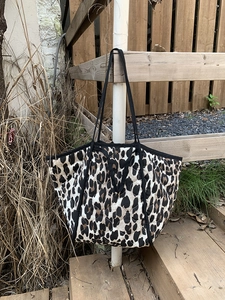 Detailed view of leopard print quilted tote bag with black strap and padded texture