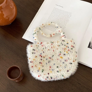 Gros plan d'un sac à main tissé en peluche blanche avec des taches colorées