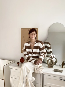 Détail du cardigan en maille rayée marron et blanc avec texture pelucheuse et col V