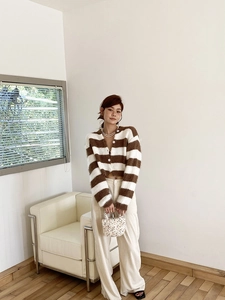 Gros plan du cardigan en maille pelucheuse à rayures marron et blanc avec boutons