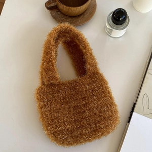 Gros plan détaillé d'un sac à main tissé en peluche marron avec fibres métalliques