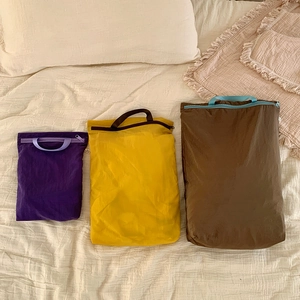 Three-piece ultralight nylon travel storage bag set in purple, yellow, and brown colors