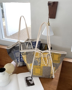 Detalle del bolso tote de lona paisley con botón de presión y bordes blancos