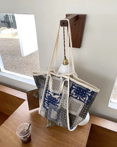Detalle del bolso tote grande de lona con estampado de bandana y cierre de botón a presión