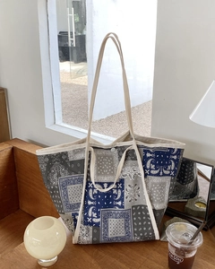 Detalle de un bolso tote de lona de retazos paisley vintage en una mesa de madera