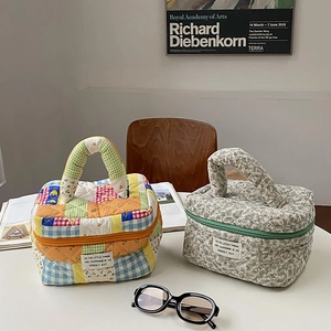 Detail of floral and checkered quilted cotton makeup bags with sturdy handles in a cozy setting