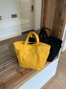 Dettaglio di borse tote in nylon resistente nei colori giallo e nero per uso quotidiano