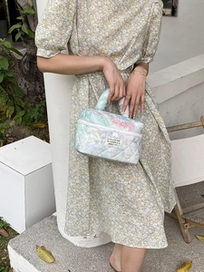 Detailed close-up of quilted floral cosmetic bag featuring watercolor flower patterns