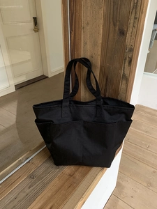 Dettaglio della grande borsa tote in nylon nero con pratiche tasche esterne