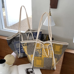Bolsos tote vintage de lona paisley amarillos y azules sobre una mesa de madera