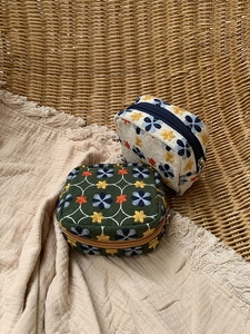 Detailed embroidery on canvas mini pouches with flower patterns and zipper closure