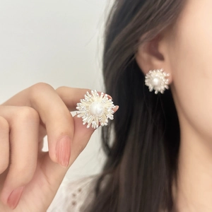 Elegant shell pearl earrings with zircon inlay floral design shown on hand for women