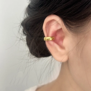 Minimalist gold textured ear cuff for women shown on ear in a stylish vertical striped design