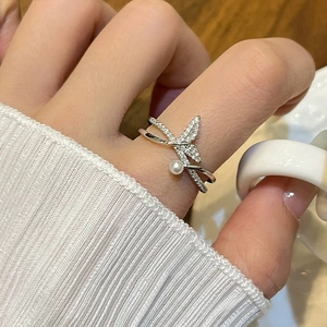 Elegant fishtail pearl ring with zircon accents in a layered silver crossover design