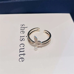 Detail of rose gold fishtail ring with pearls and micro-pave zircons on a display card