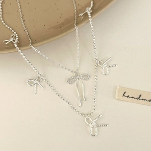 Elegant double-layer silver bow necklace with sparkling crystals and braided metal charms