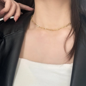 Minimalist gold paperclip chain necklace for women shown on neck with a black leather jacket