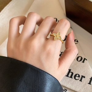 Elegant gold flower ring with clover design and pave zircon crystals on model hand