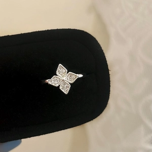 Detail of silver clover ring with zircon inlay presented in a black velvet jewelry box