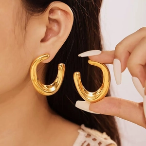 Polished gold thick C-shaped hoop earrings featuring a minimalist streamlined design