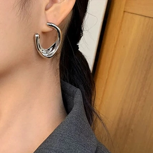 Minimalist silver C-shaped irregular earrings shown on a model for a modern look