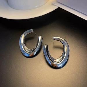Macro view of silver chunky U-shaped earrings with a high-polished metallic finish