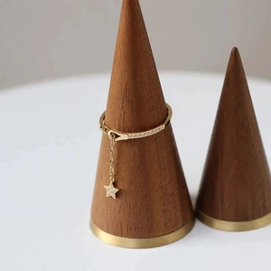 Bague étoile dorée minimaliste avec zircons sur un support en bois de qualité