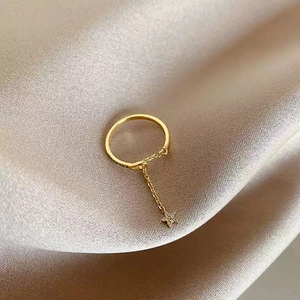 Détail d'une bague dorée avec pendentif étoile en zircon sur un fond de soie élégant