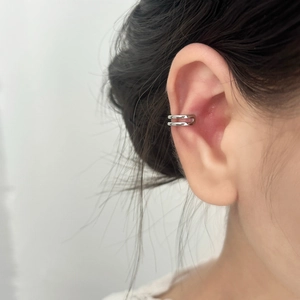 Close-up of minimalist silver double-layer ear cuff on model showing sleek metallic finish