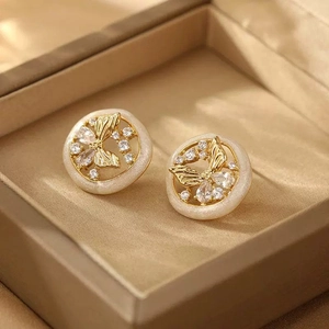 Elegant gold butterfly stud earrings with zircon and cream enamel in a velvet jewelry box