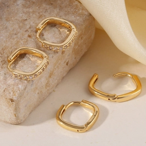 Minimalist gold geometric hoop earrings set with polished and zircon styles on stone background
