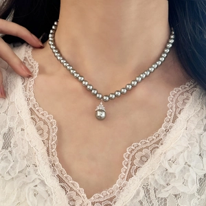 Elegant silver-grey pearl necklace with a crown-set irregular pendant on lace top