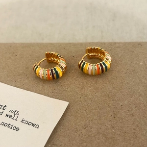 Détail de créoles dorées rétro françaises avec émail coloré à rayures artisanales