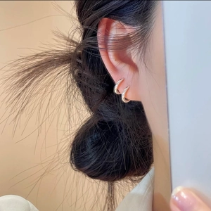 Minimalist silver-polished C-shape hoop earrings for layered wear on model