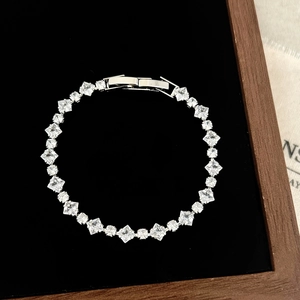 Macro view of silver tennis bracelet with square-cut zircons in a black jewelry box
