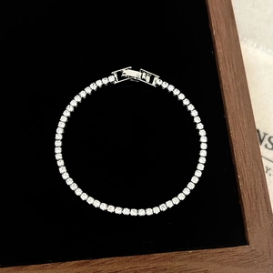 Macro detail of tennis bracelet with brilliant round cut zircons on black velvet base