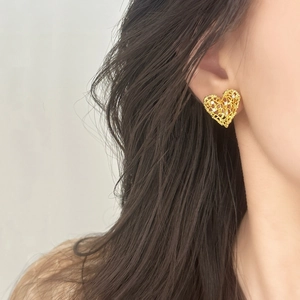 Elegant gold hollow heart earrings with shimmering zircon accents on model