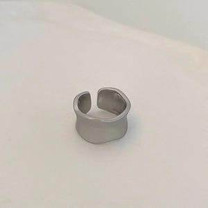 Dettaglio di un anello regolabile argento opaco con design a fascia ondulata irregolare