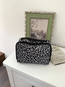 Detail van de luipaardprint make-uptas met ritssluiting en stevige zwarte handgreep