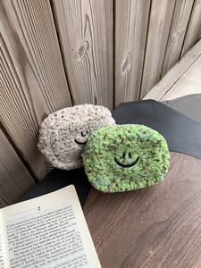 Nahaufnahme flauschiger Sherpa-Plüsch-Geldbörsen mit Smiley-Stickerei und Metallreißverschluss