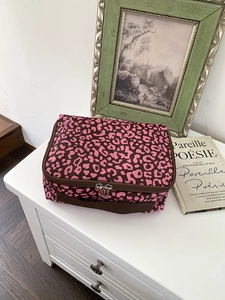 Detail van de luipaardprint make-up tas met dubbele rits en zijhandgreep