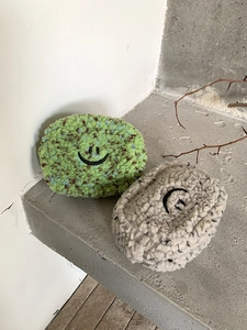Detailansicht der flauschigen Smiley-Minitaschen aus grünem und grauem Plüschstoff