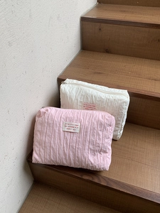 Quilted nylon travel makeup bag with vertical pleats and zipper closure in pink and cream